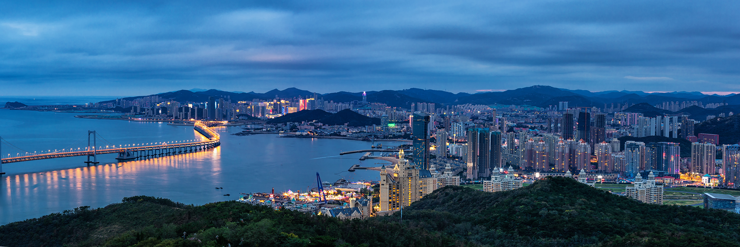 Dalian city skyline and bay illuminated at night
